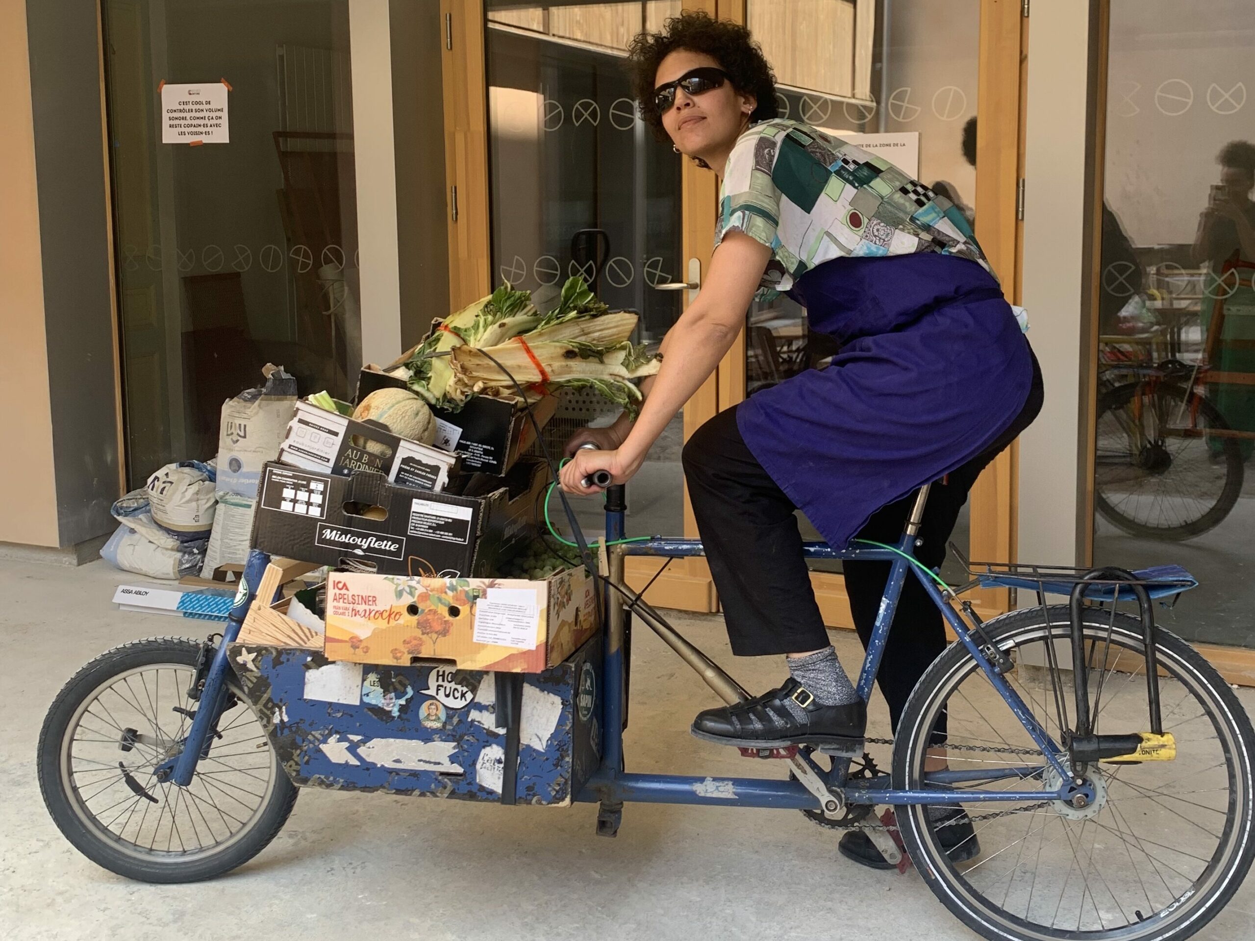Membre de l'association La Coco Cantine qui revient d'un marché du 19ème arrondissement de Paris sur un vélo biporteur chargé de d'invendus alimentaires sauvés de la poubelle.