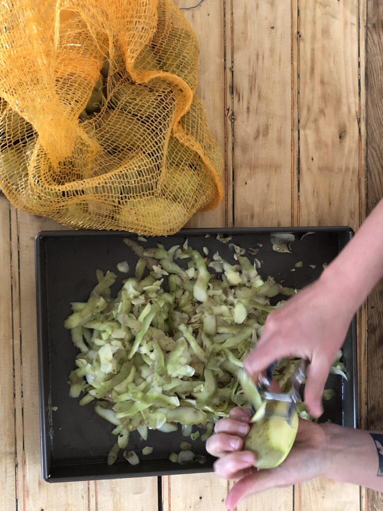 Photos couleur illustrant le travail bénévole collaboratif autour de la cuisine à la Coco Cantine, restaurant associatif du 20ème arrondissement de Paris qui s'attèle aux problématiques de l'accessibilité du bien manger et de l'alimentation durable pour toustes. - Épluchage de pommes de terres bio pour faire des patates frites pour le bar.