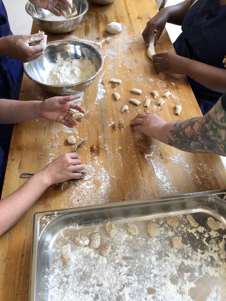 Photos couleur illustrant le travail bénévole collaboratif autour de la cuisine à la Coco Cantine, restaurant associatif du 20ème arrondissement de Paris qui s'attèle aux problématiques de l'accessibilité du bien manger et de l'alimentation durable pour toustes. - Confection de gnocchis à la banane pour utiliser créativement les énormes quantités de bananes bio invendues récupérées par l'association.